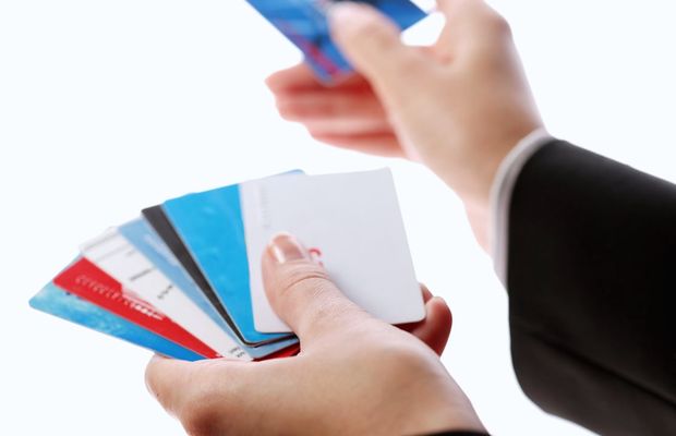 Hands fanning out a row of payment cards