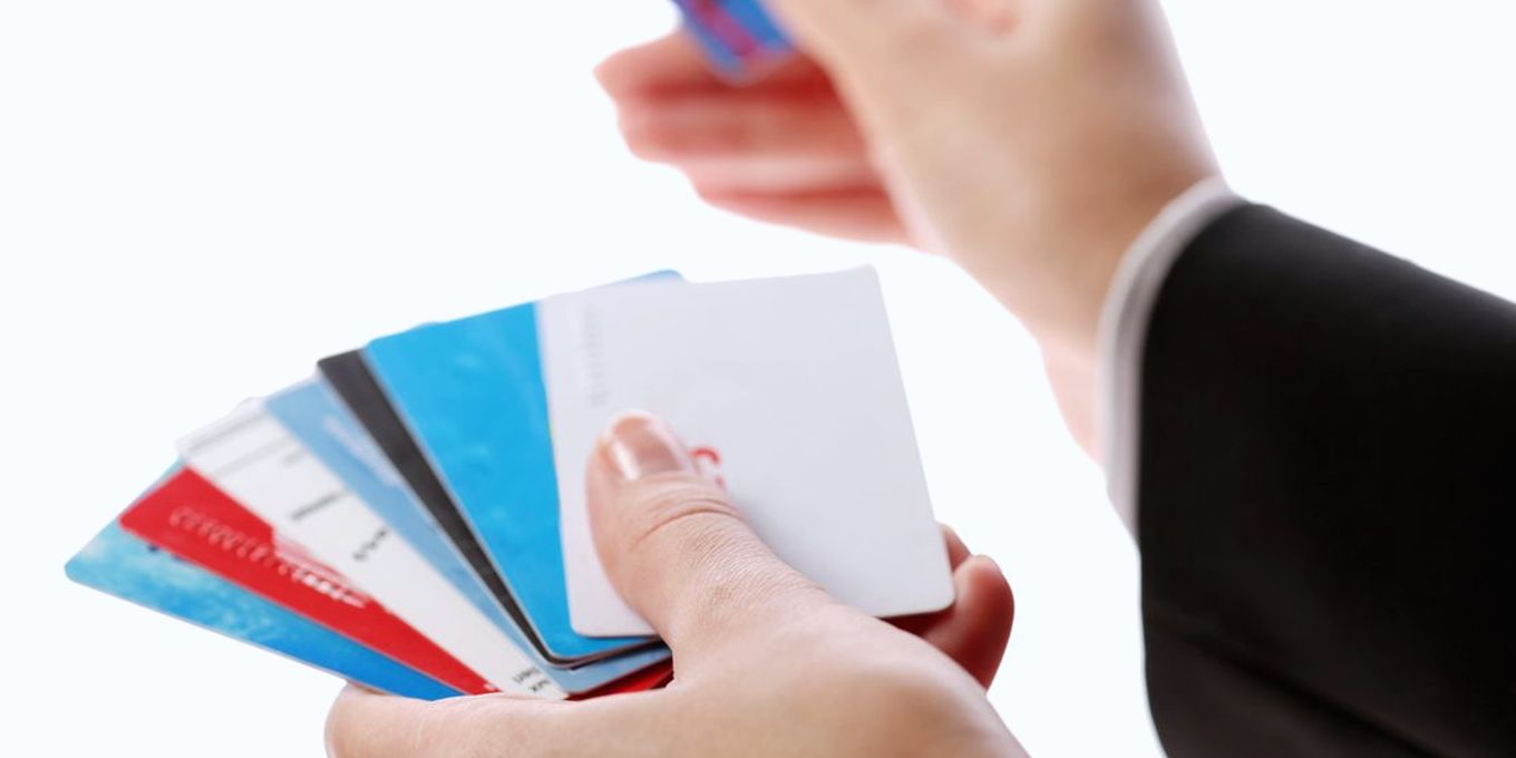 Hands fanning out a row of payment cards