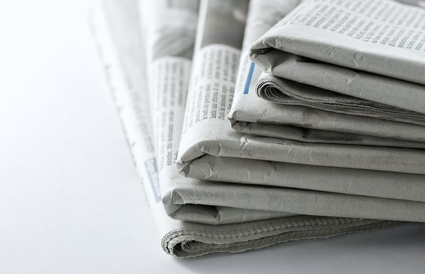 A stack of folded newspapers