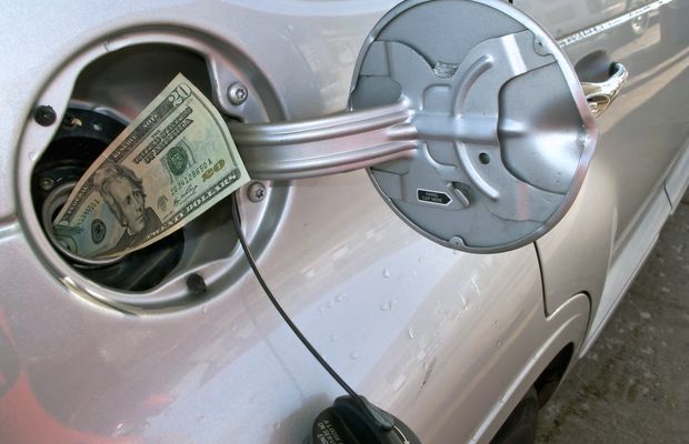 A dollar bill tucked into a car's open fuel filler