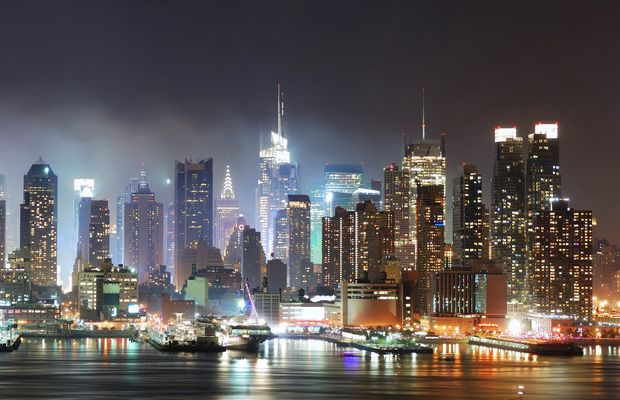 The Manhattan skyline lit up at night across the water